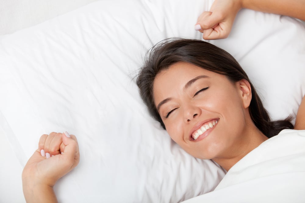 Rested woman waking up refreshed without jaw pain after physical therapy for clenching