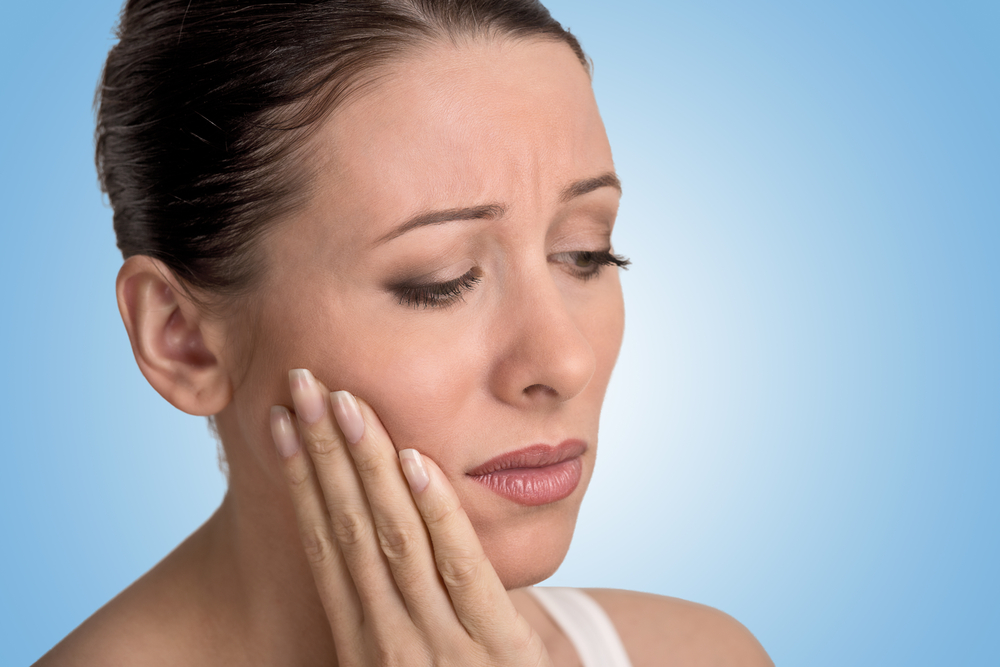 Woman experiencing jaw pain post-radiation fibrosis