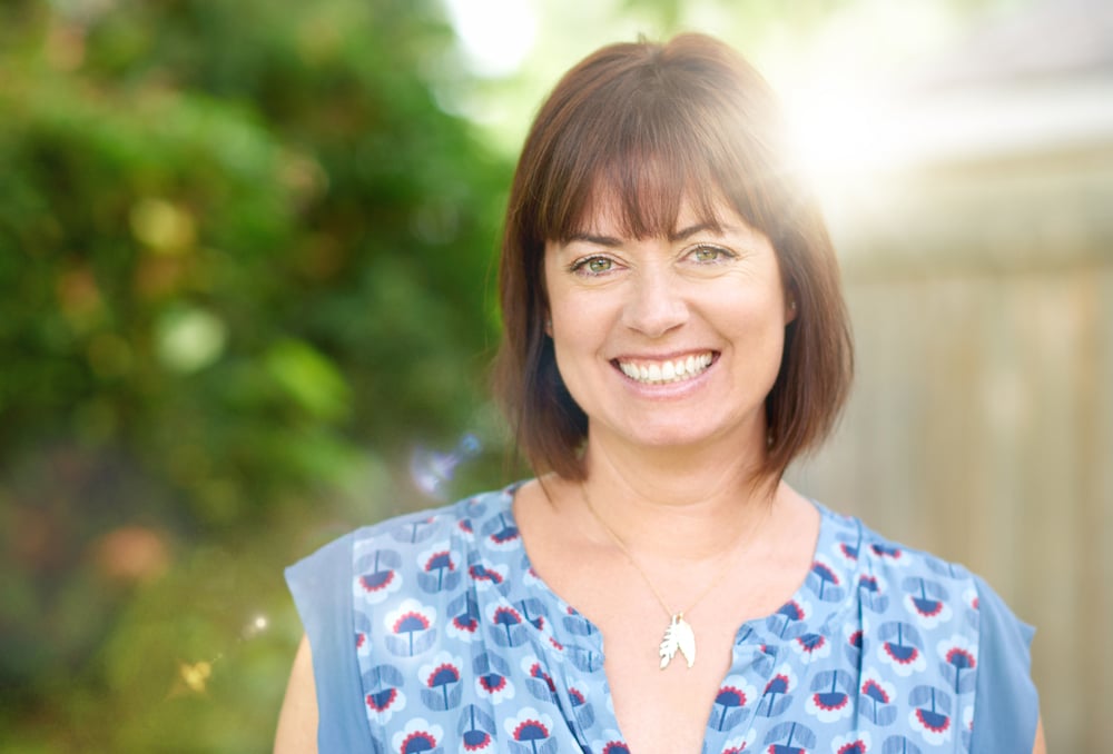 Smiling mature woman outdoors, relaxed and free of facial pain after physical therapy